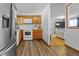 An angled kitchen shot revealing wood cabinets and floors, and views into the living room at 1263 W 103Rd Pl, Northglenn, CO 80260