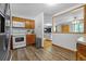 Efficient kitchen featuring oak cabinets, white appliances, and hardwood floors, conveniently connected to the living areas at 1263 W 103Rd Pl, Northglenn, CO 80260