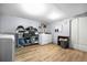 Organized laundry room with light wood floors, washer, dryer, shelving, and ample storage space at 1263 W 103Rd Pl, Northglenn, CO 80260