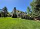 Expansive backyard with a well-manicured lawn, mature trees, and a covered patio perfect for outdoor entertaining at 8535 E Otero Cir, Centennial, CO 80112