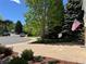 Paver driveway showcases the welcoming exterior of this home, complete with mature trees and an American flag at 8535 E Otero Cir, Centennial, CO 80112