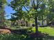 Back exterior view with lush greenery, covered patio, and manicured lawn offering outdoor living space at 8535 E Otero Cir, Centennial, CO 80112