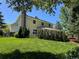 Home exterior with spacious lawn, covered patio, mature trees, and neat landscaping at 8535 E Otero Cir, Centennial, CO 80112