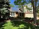Charming home featuring solar panels, a brick facade, lush lawn, mature trees and beautiful landscaping at 8535 E Otero Cir, Centennial, CO 80112