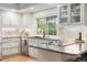 Bright kitchen features granite countertops, white cabinets, modern appliances, and hardwood floors at 8535 E Otero Cir, Centennial, CO 80112