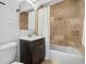 Bathroom with a modern vanity, tiled shower and tub combo and decorative mirror at 1812 S Hazel Ct, Denver, CO 80219