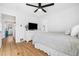 Bright bedroom features a ceiling fan, hardwood floors and a white dresser at 1812 S Hazel Ct, Denver, CO 80219