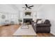 Bright living room with hardwood floors, large windows, fireplace, and modern ceiling fan at 1812 S Hazel Ct, Denver, CO 80219