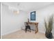 Cozy home office featuring neutral carpet, a wooden desk, and a modern decorative art piece on the wall at 1812 S Hazel Ct, Denver, CO 80219