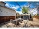 Backyard patio featuring pavers, gravel, wooden fence, string lights, and a cozy seating area with cushioned wicker furniture at 444 Inca St, Denver, CO 80204