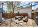 Backyard patio features pavers, gravel, wooden fence, string lights, and a cozy seating area with cushioned wicker furniture at 444 Inca St, Denver, CO 80204
