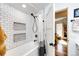 Bathroom with shower and tub featuring white tile and geometric patterned tile in shower shelving at 444 Inca St, Denver, CO 80204