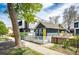 A charming home featuring a yellow front door and a lovely white fence, perfect curb appeal at 444 Inca St, Denver, CO 80204
