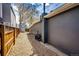 Narrow side yard with gravel, wooden fence, and utilities installed on the side of the house at 444 Inca St, Denver, CO 80204