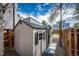 Backyard view of a vinyl storage shed with windows and shutters, accessible via a paved walkway at 444 Inca St, Denver, CO 80204