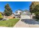 Two-story home boasts a well-manicured lawn, mature trees, and a two-car garage at 21924 E Lake Ave, Aurora, CO 80015