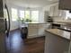 Bright kitchen features granite countertops, white cabinets, wood floors, and a bay window at 21924 E Lake Ave, Aurora, CO 80015