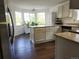Bright kitchen features granite countertops, white cabinets, wood floors, and a bay window at 21924 E Lake Ave, Aurora, CO 80015