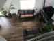 Sun-filled living room offering hardwood floors, comfortable seating, and a large TV, ideal for gatherings at 21924 E Lake Ave, Aurora, CO 80015
