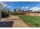 Spacious backyard with a combination of grass and gravel areas, framed by a wooden fence for privacy at 9880 W 76Th Pl, Arvada, CO 80005
