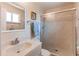 Bathroom featuring a vanity with a sink, a toilet, and a shower stall with glass doors and tile surround at 9880 W 76Th Pl, Arvada, CO 80005