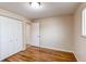 Bedroom featuring hardwood floors, neutral walls, a window, and a closet door at 9880 W 76Th Pl, Arvada, CO 80005
