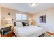 Comfortable bedroom featuring bright neutral walls, hardwood floors, and a window with natural light at 9880 W 76Th Pl, Arvada, CO 80005