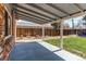 Covered back patio offers a peaceful outdoor space with a lush lawn, stone landscaping, and a privacy fence at 9880 W 76Th Pl, Arvada, CO 80005