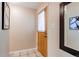 Warm and inviting entryway with tiled floors and an wood door with decorative mirror at 9880 W 76Th Pl, Arvada, CO 80005