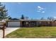 Attractive single-story home with a well-kept lawn, a brick facade, and a spacious driveway at 9880 W 76Th Pl, Arvada, CO 80005