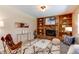 Comfortable living room with cozy seating, a fireplace, and built-in shelving at 9880 W 76Th Pl, Arvada, CO 80005