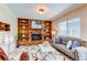Cozy living room with fireplace, built-in bookshelves, and lots of natural light at 9880 W 76Th Pl, Arvada, CO 80005