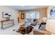Bright and inviting living room featuring stylish furniture, and large window, perfect for relaxation at 9880 W 76Th Pl, Arvada, CO 80005