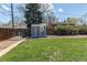 Backyard with a storage shed, a lush lawn, and a gravel area, perfect for outdoor activities at 9880 W 76Th Pl, Arvada, CO 80005