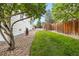 Side yard featuring green grass, rock landscaping, and trees at 4545 Oxbow Dr, Brighton, CO 80601