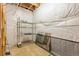 Unfinished basement area with plastic wall covering, metal shelving and carpeted floor at 4545 Oxbow Dr, Brighton, CO 80601