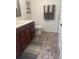Modern bathroom with a vanity, updated flooring, and a decorative mirror at 4545 Oxbow Dr, Brighton, CO 80601