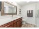 Bright bathroom featuring a wood-framed mirror, white countertops, and a glass-enclosed shower at 4545 Oxbow Dr, Brighton, CO 80601