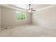 Bright bedroom with plush carpet, ceiling fan, and ample natural light from the large window at 4545 Oxbow Dr, Brighton, CO 80601