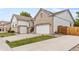 Side view of house with three-car garage, stone landscaping, and manicured lawn at 4545 Oxbow Dr, Brighton, CO 80601