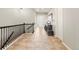 Hallway with tile flooring, elegant console table and mirror, complemented by a black wrought iron stair railing at 4545 Oxbow Dr, Brighton, CO 80601