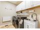 Well-equipped laundry room with modern washer, dryer, utility sink, and ample storage cabinets at 4545 Oxbow Dr, Brighton, CO 80601