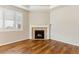 Cozy living room with gas fireplace, wood floors, and large window at 4545 Oxbow Dr, Brighton, CO 80601