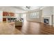 Spacious living area with hardwood floors, fireplace, open kitchen, and modern lighting at 4545 Oxbow Dr, Brighton, CO 80601