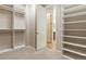 Bright walk-in closet with built-in shelving for organization and easy access to the main bathroom at 4545 Oxbow Dr, Brighton, CO 80601