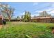 A fenced backyard featuring grass and large trees at 12603 E Ohio Ave, Aurora, CO 80012