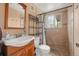 Bathroom features vanity with sink, toilet, tiled walk-in shower, and window at 12603 E Ohio Ave, Aurora, CO 80012