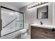 Updated bathroom featuring stylish vanity, modern light fixtures, and shower with glass doors at 7080 W 20Th Ave # 202, Lakewood, CO 80214