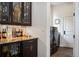 Elegant bar area features granite counters, mirrored backsplash, and glass storage for showcasing beverages at 2117 S Juniper St, Lakewood, CO 80228