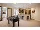 Basement bar with dark wood cabinets, counter seating, and access to a game room at 2117 S Juniper St, Lakewood, CO 80228